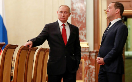 Russian President Putin and Prime Minister Medvedev speak before a meeting with government members in Moscow
